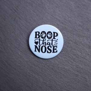 Boop That Nose Button. These buttons are made with photo paper, metal round, and metal backing. These buttons are vibrant and fun to use on bags or vests.