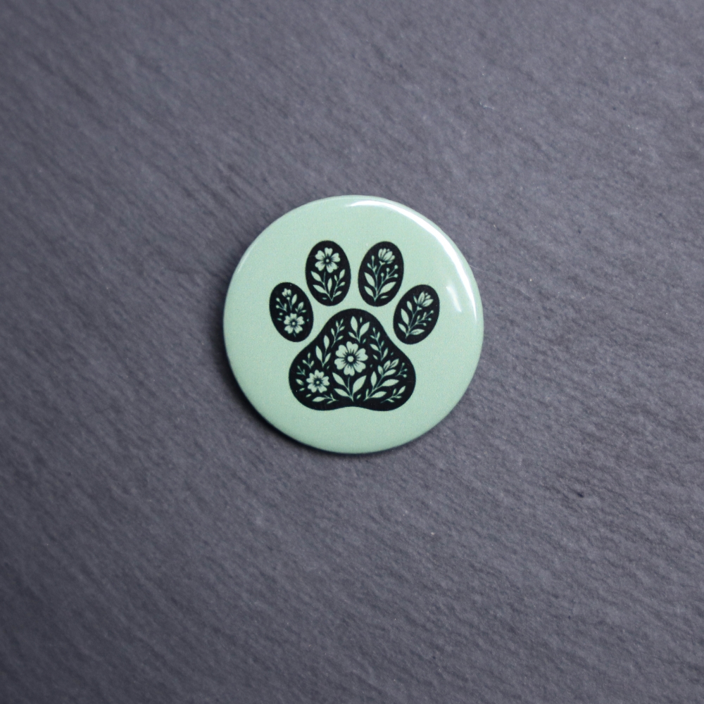 Floral Paw Green Button. These buttons are made with photo paper, metal round, and metal backing. These buttons are vibrant and fun to use on bags or vests.