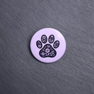 Floral Paw Purple Button. These buttons are made with photo paper, metal round, and metal backing. These buttons are vibrant and fun to use on bags or vests.