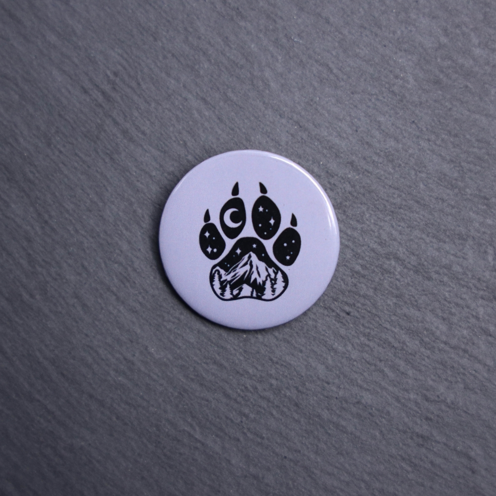 Forest Paw Gray Button. These buttons are made with photo paper, metal round, and metal backing. These buttons are vibrant and fun to use on bags or vests.