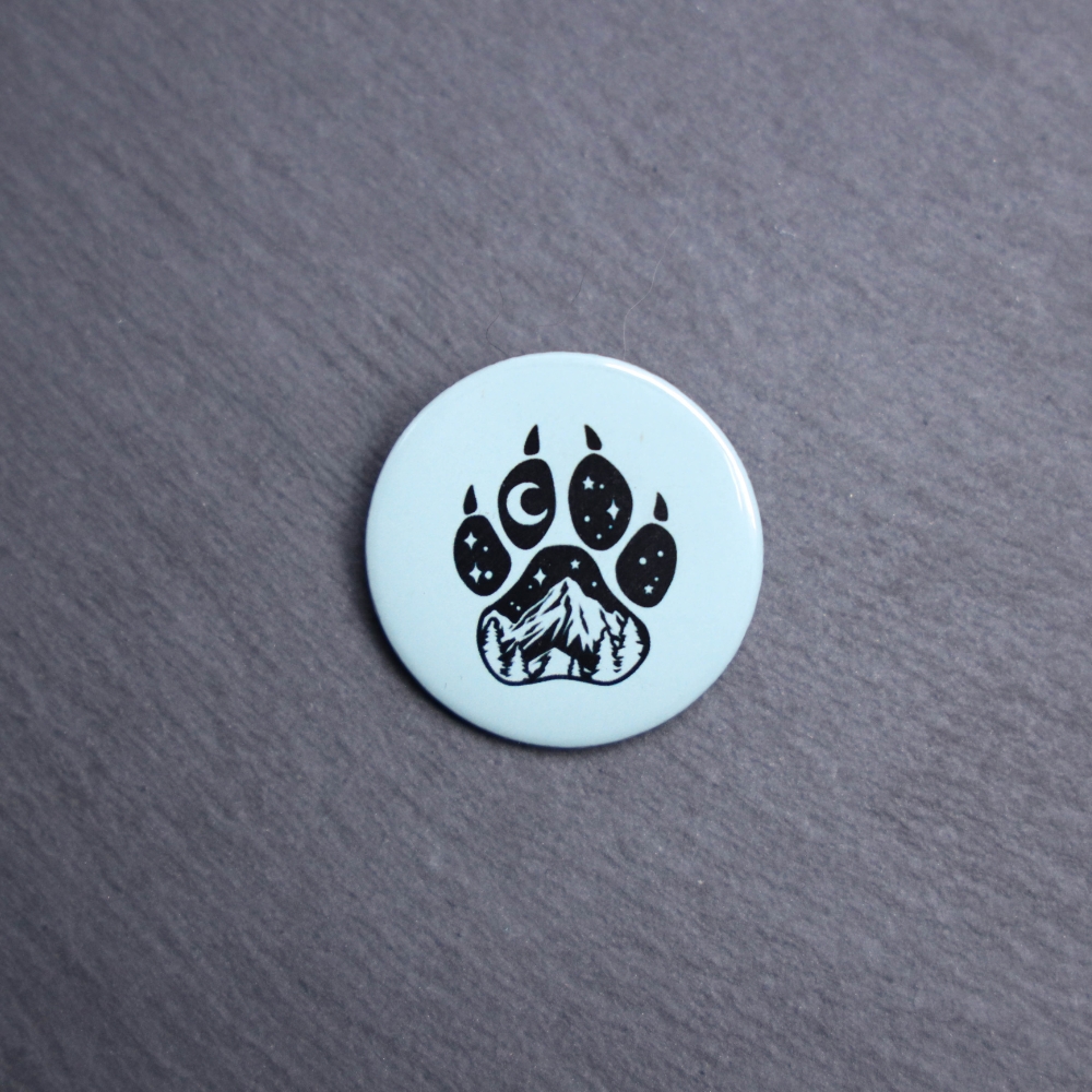Forest Paw Light Blue Button. These buttons are made with photo paper, metal round, and metal backing. These buttons are vibrant and fun to use on bags or vests.