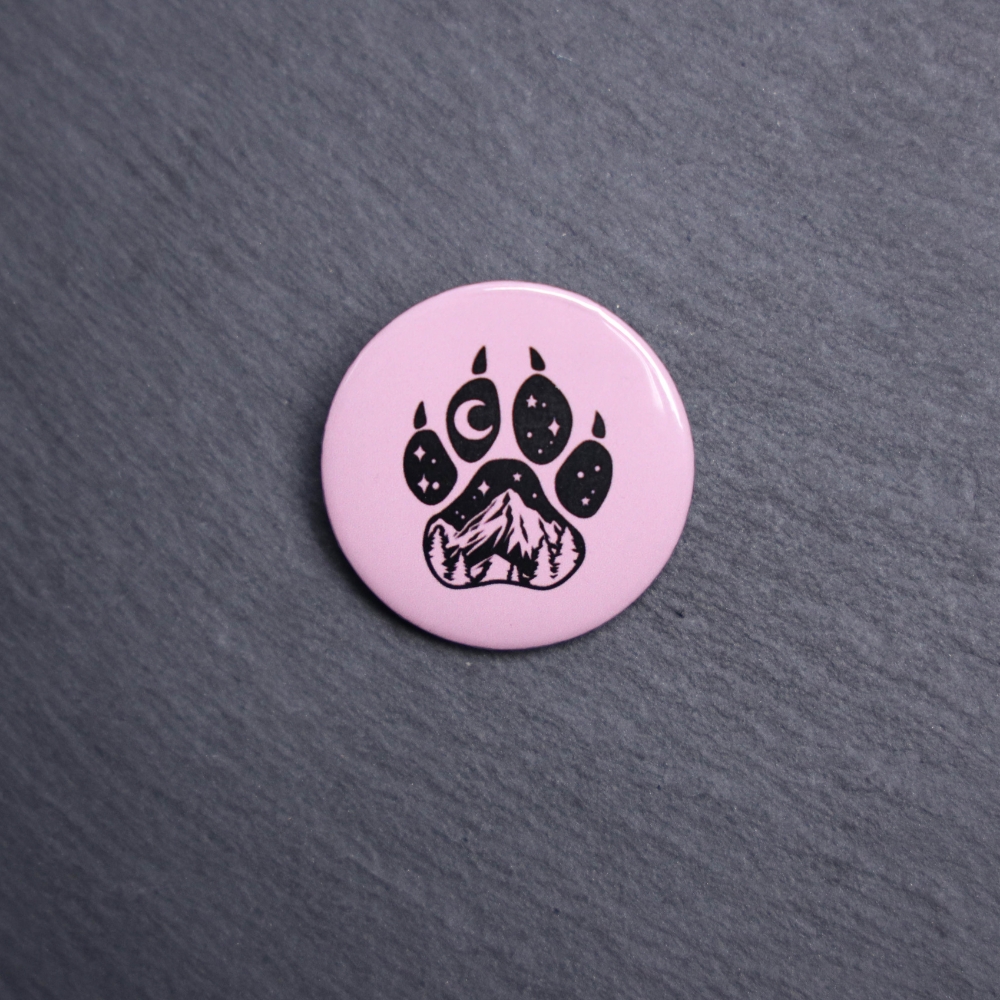 Forest Paw Pink Button. These buttons are made with photo paper, metal round, and metal backing. These buttons are vibrant and fun to use on bags or vests.