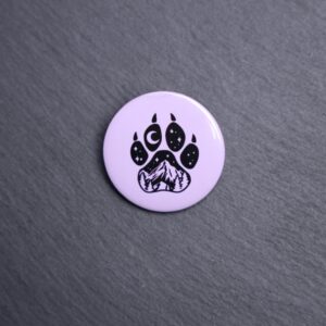 Forest Paw Purple Button. These buttons are made with photo paper, metal round, and metal backing. These buttons are vibrant and fun to use on bags or vests.