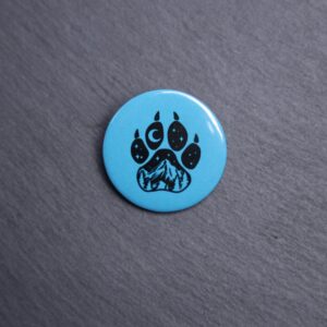 Forest Paw Dark Teal Button. These buttons are made with photo paper, metal round, and metal backing. These buttons are vibrant and fun to use on bags or vests.